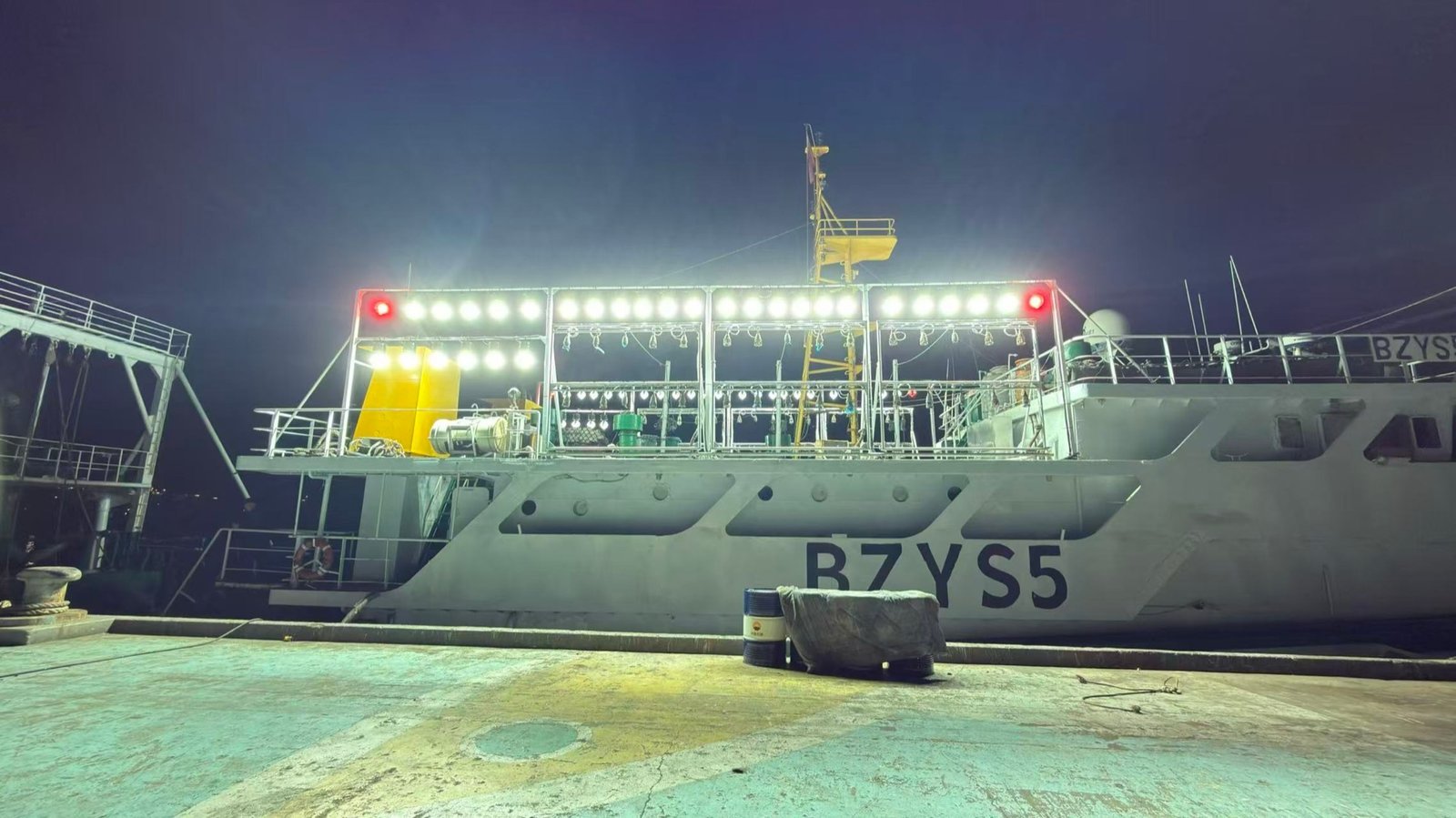 Night view of a commercial fishing vessel light array near the bridge and working deck
